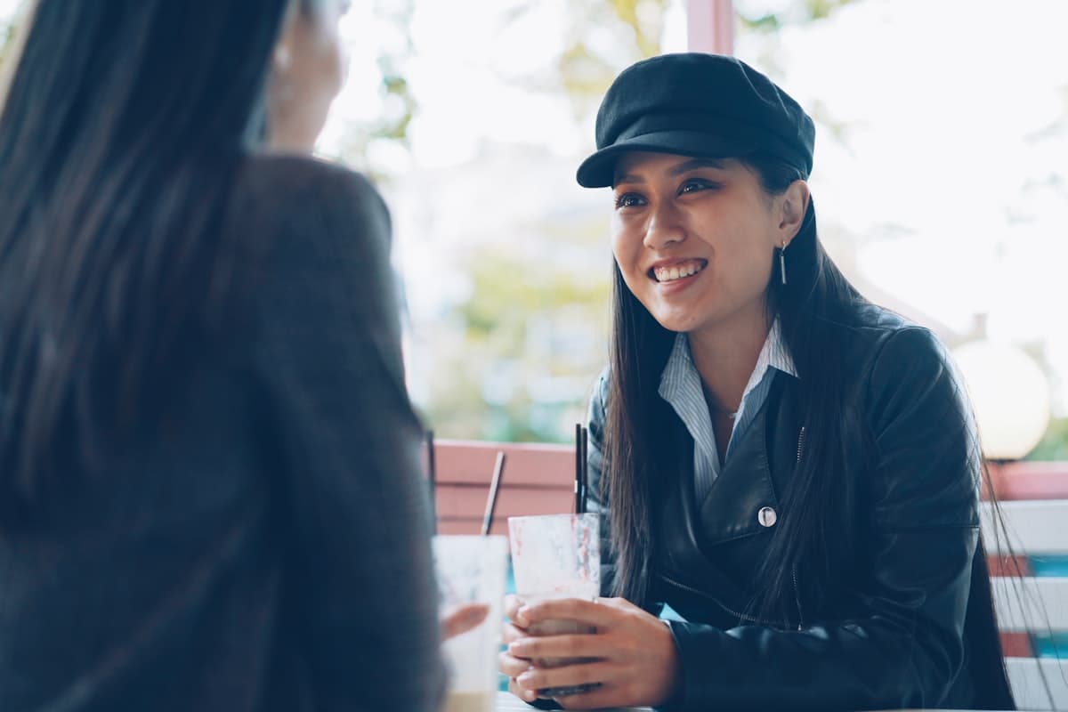 兩位女性在咖啡廳窗邊開心交談